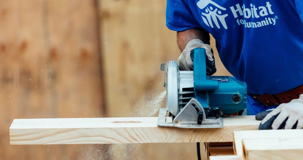 A staff member saws lumber