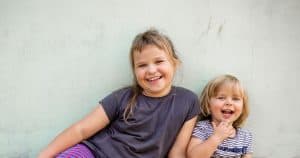 Weronika Kawka, 7, and her sister Amelka Kawka, 2, in front of one of the walls of the home being built for them by volunteers with Habitat for Humanity