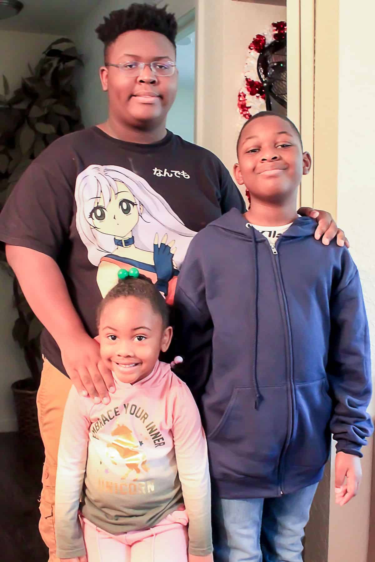 Three children standing in hallway