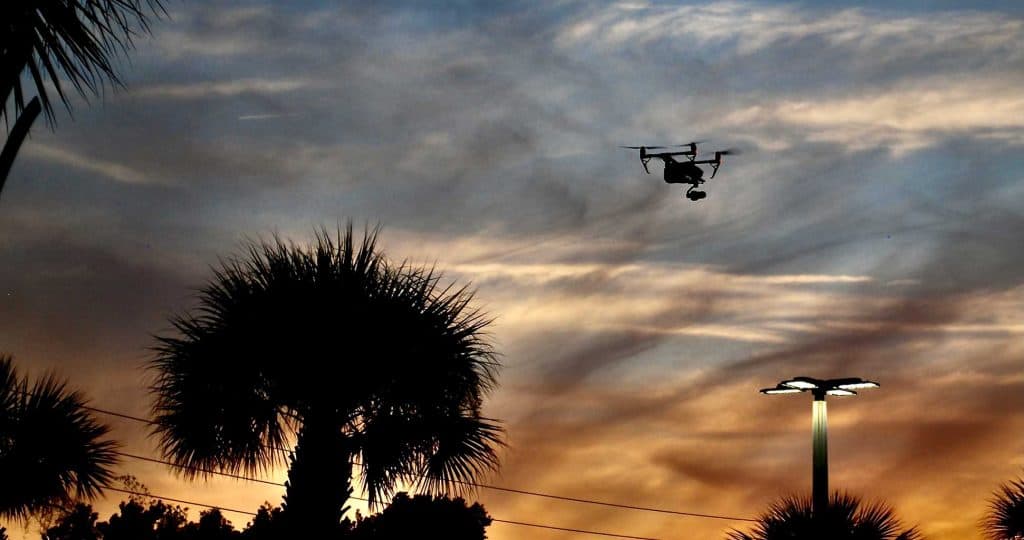 Backlit drone in sky at sunset