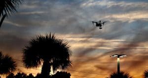 Backlit drone in sky at sunset