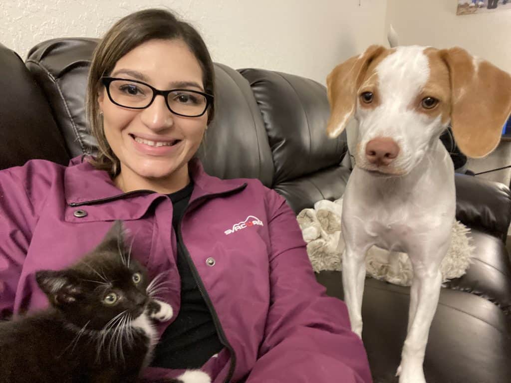 Women on couch with kitten and puppy