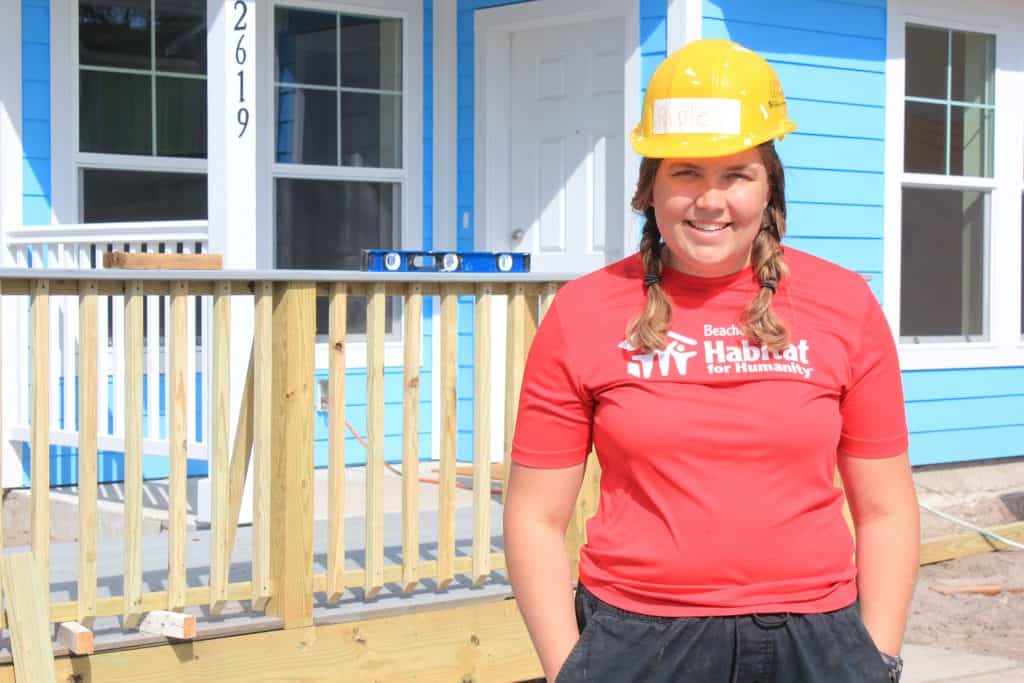 Young woman in yellow hard hat and red shirt