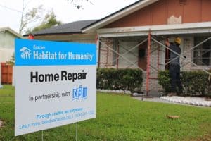 A senior repair home with a home repair sign in the front yard showcasing Beaches Habitat's partnership with the Beaches Emergency Assistance Ministry, BEAM.