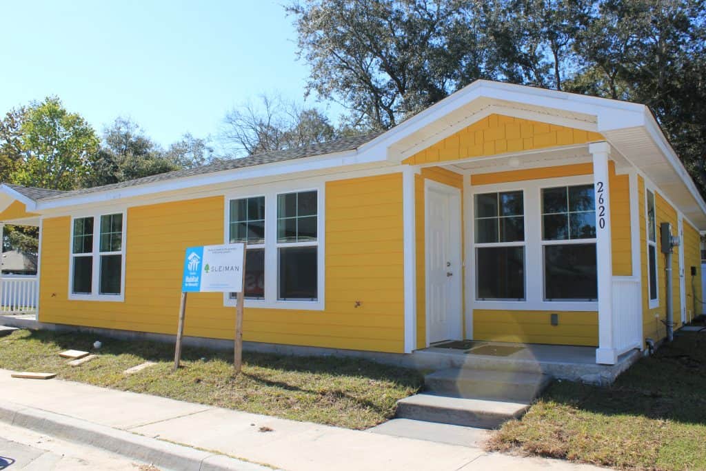 Front view of a single-story yellow duplex in Haywood Estates II that has been built by Beaches Habitat and volunteers. 
