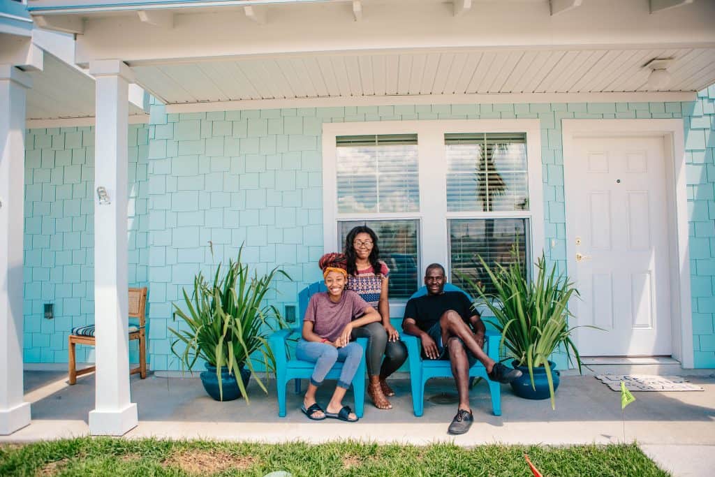 Father and two daughters sitting in bright blue chairs