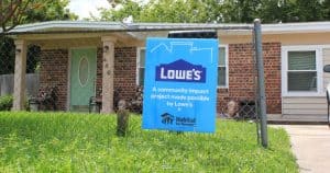 A sponsor sign sits in the front yard of a house receiving repairs by Beaches Habitat for Humanity's Senior Home Repair prrogram.