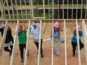 Female constructions workers lifting wall framing