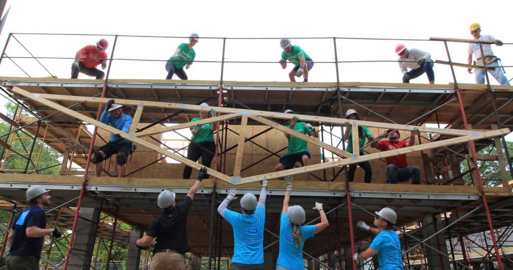 Volunteers lifting roof truss