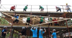 Volunteers lifting roof truss