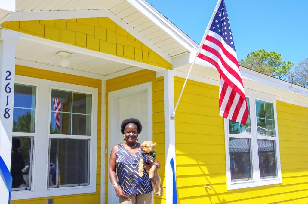 Woman on front porch holding small dog