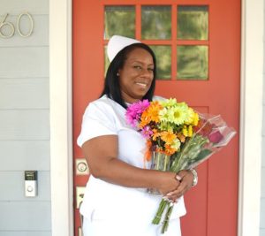 Woman in nurse's uniform holding flowers
