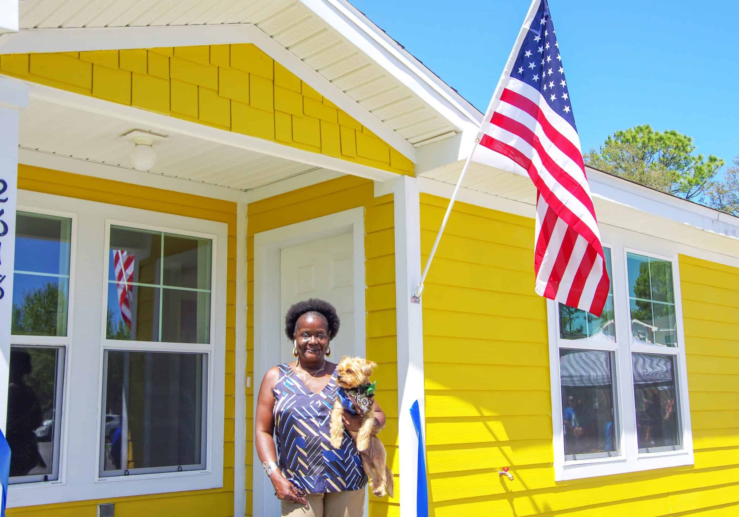 Woman on front porch holding small dog